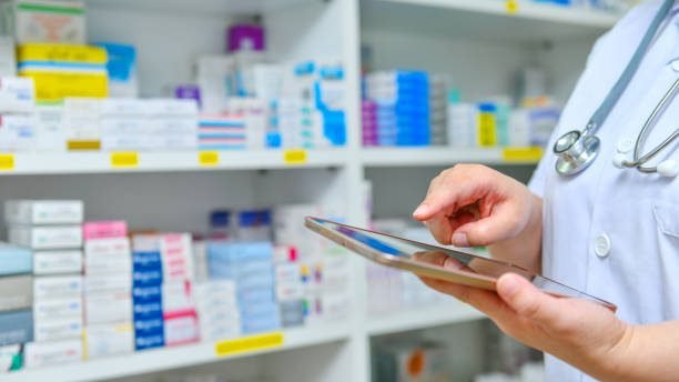 Doctor using computer tablet for search bar on display in pharmacy drugstore shelves background .Online medical concept.